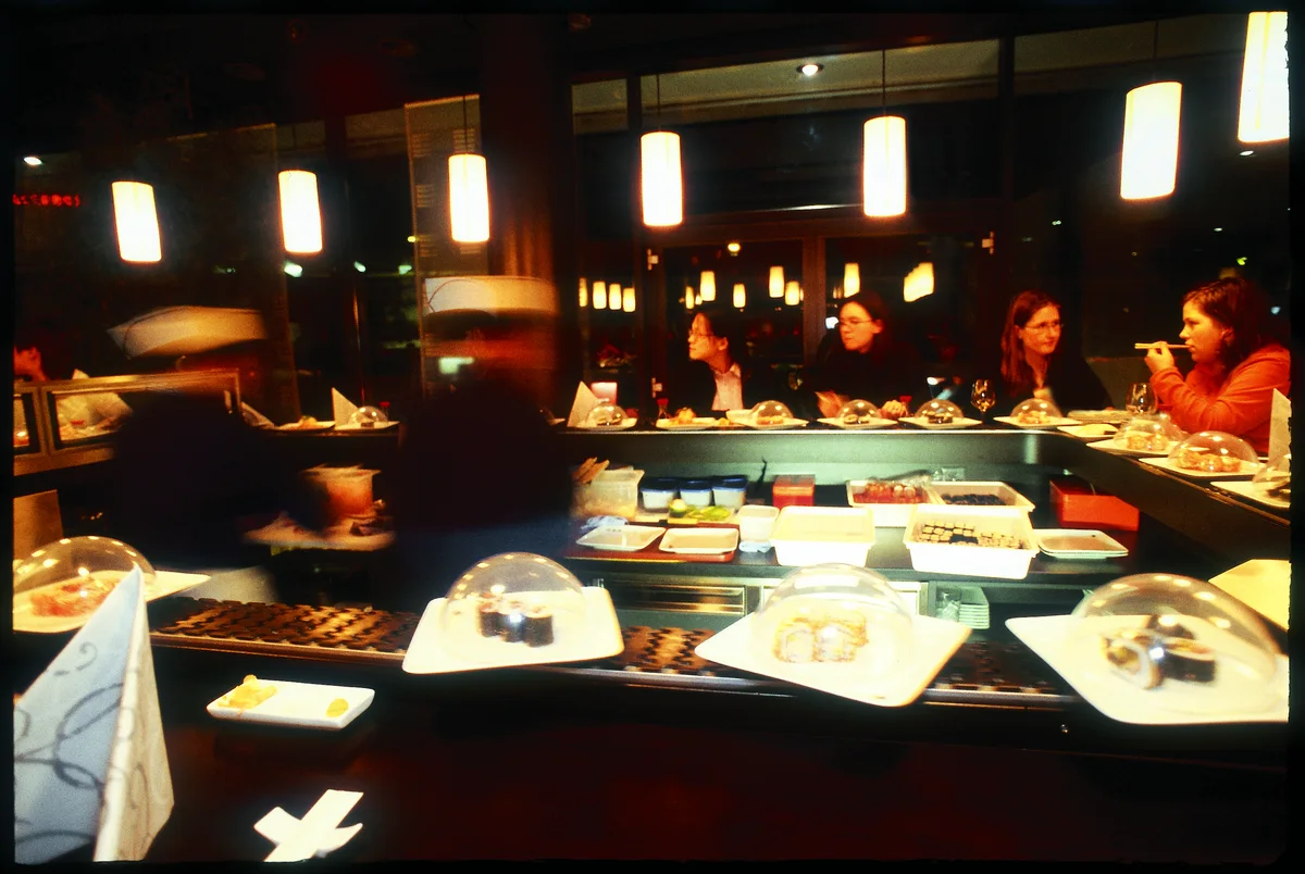 Gäste an der beleuchteten Sushi Bar