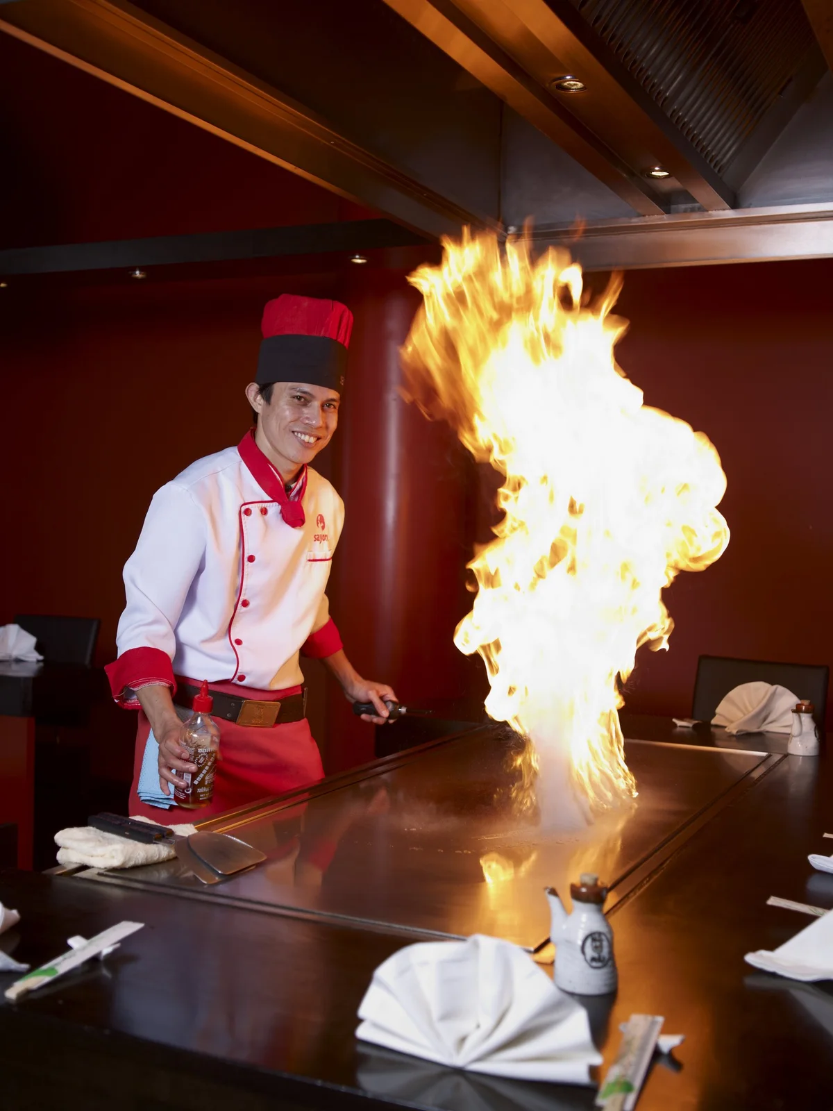 Koch mit Flamme am Teppanyaki-Grill